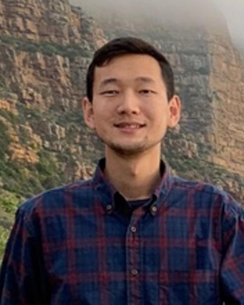 Haonan Xu standing in front of a mountain